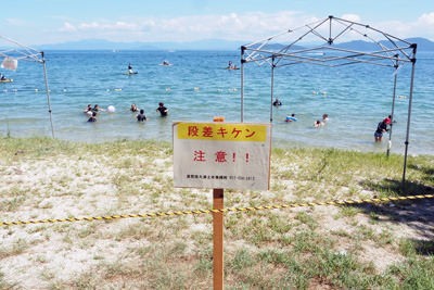 近江舞子・雄松浜の琵琶湖岸に張られた段差注意のロープや注意標示