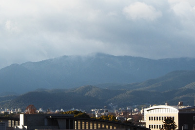 京都市街初雪の午後、山上に雪が見える愛宕山