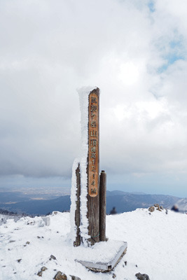 氷点下の気温に標識も凍る、雪上の武奈ヶ岳山頂